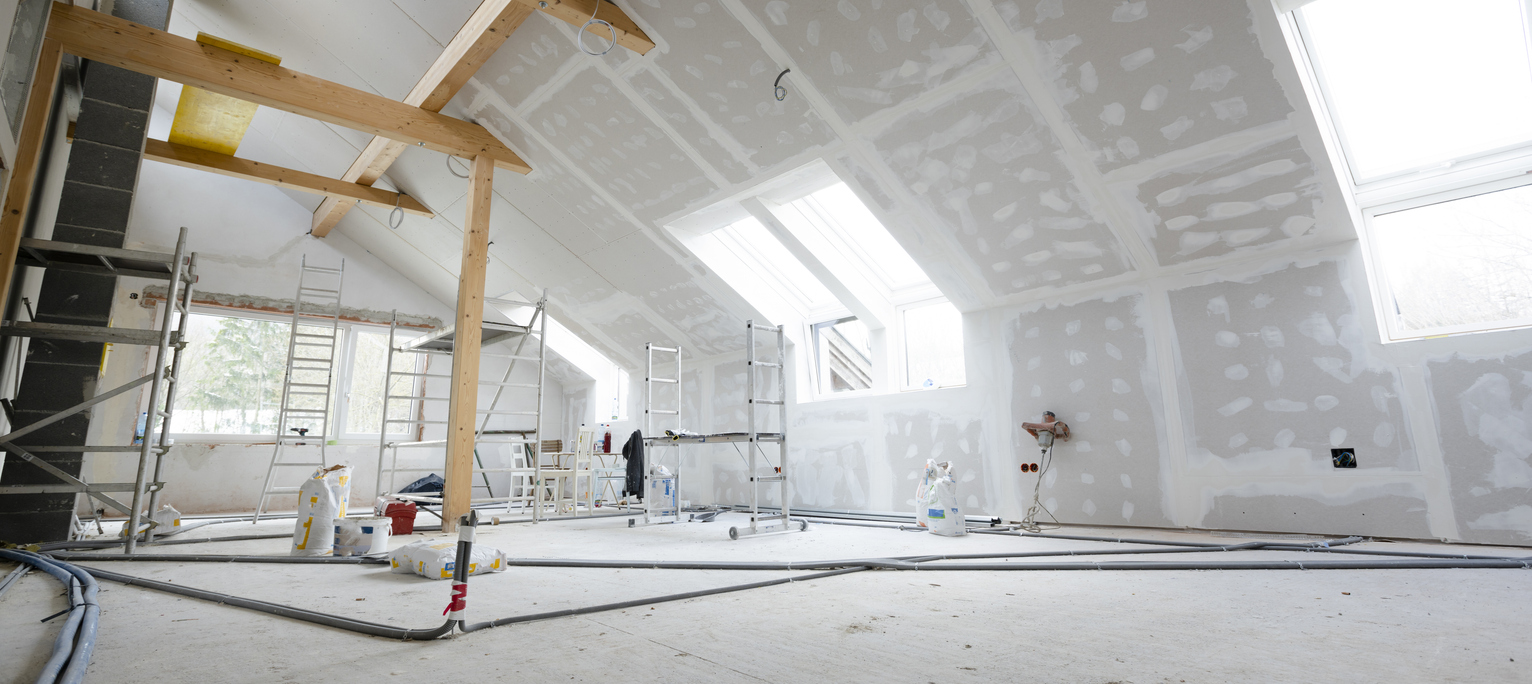 Attic finishing construction site in the phase drywall spackling and plastering before screeding